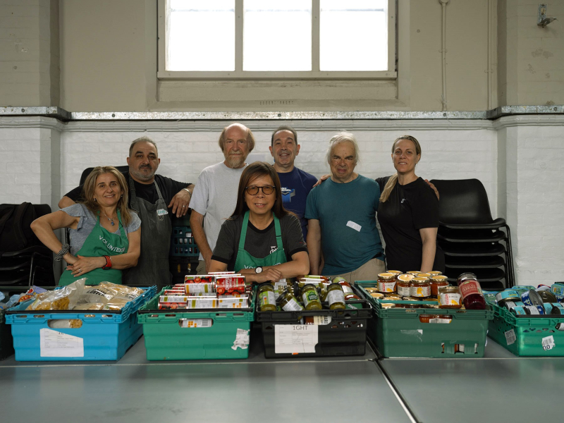 A group of people with food products for a food bank
