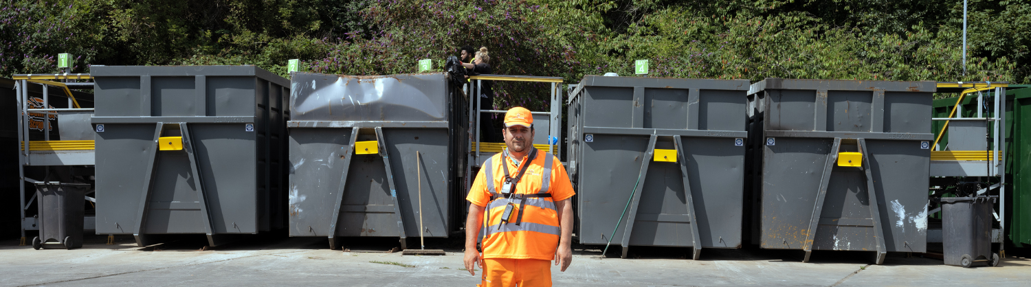 A staff member stands in front of the bunkers at a recycling centre