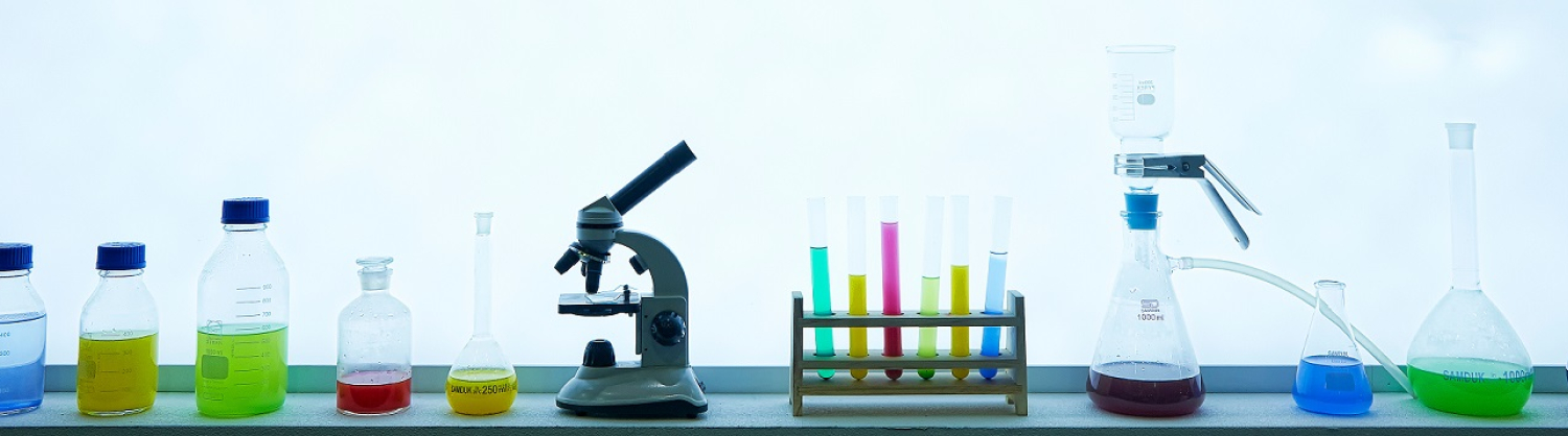 Science flasks, a microscope and beakers on a shelf