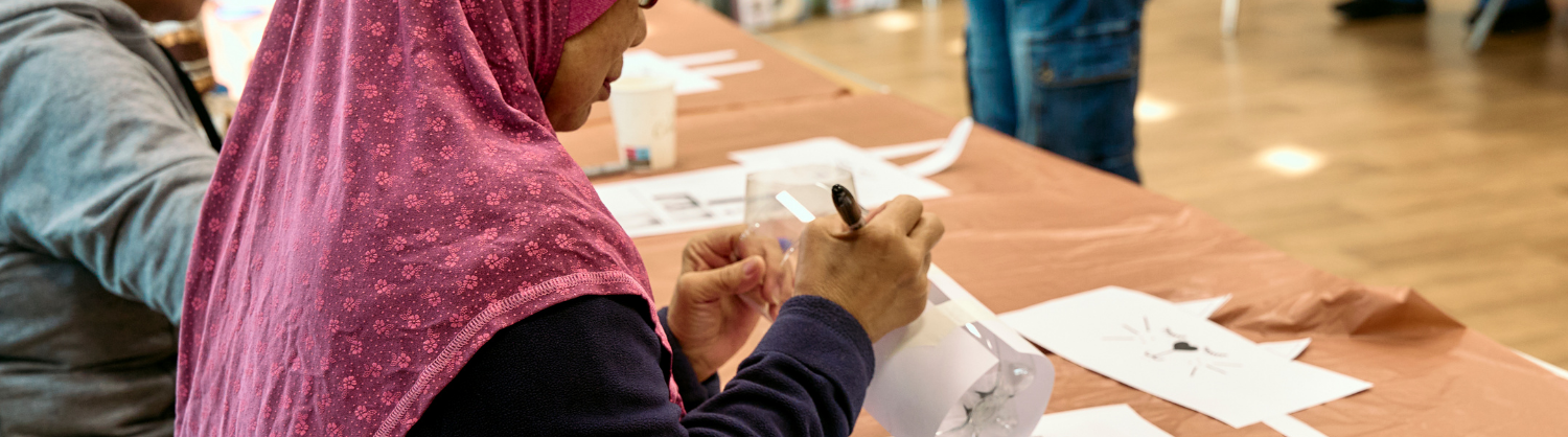 Woman painting a recycle plant pot at a Community Fund workshop