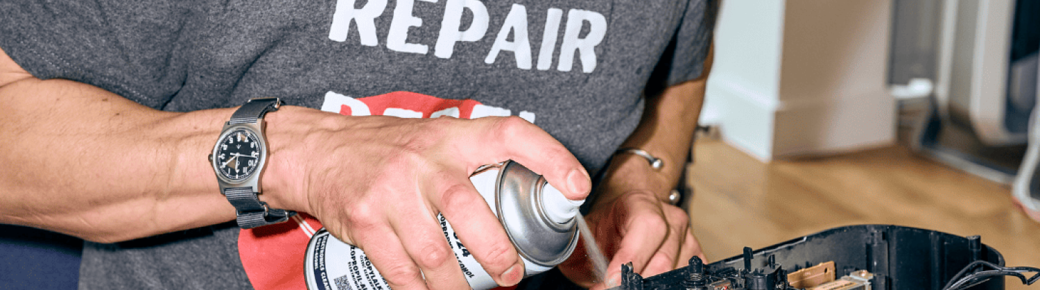 Volunteer fixer at a repair event repairing a tape player
