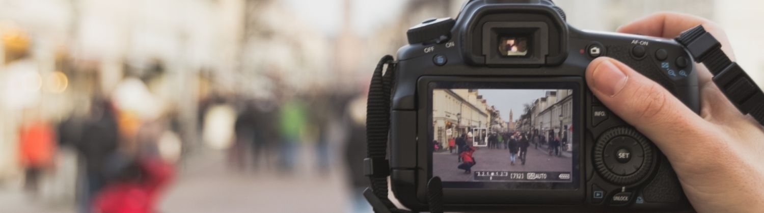 A view through the lens of a camera as someone takes a photo of a busy street. 