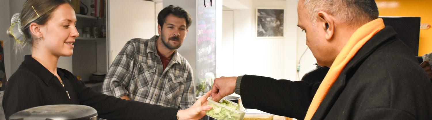 Three people sampling some chopped vegetables from a box