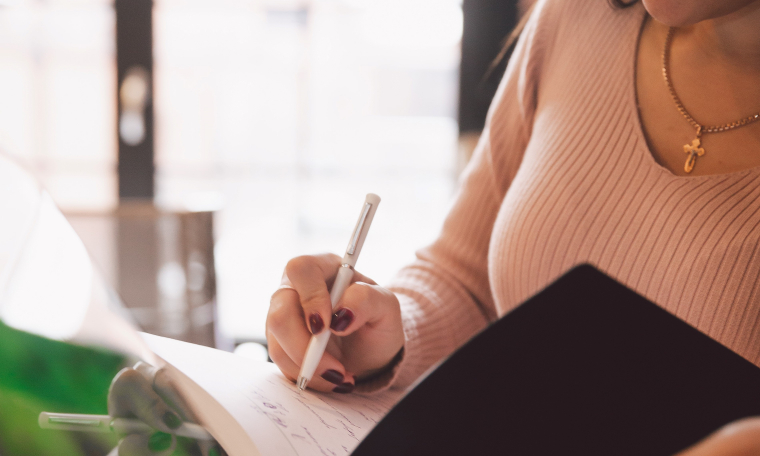 Woman writing on notebook