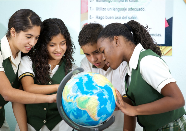 School children looking at a globe