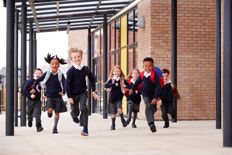 Primary school students running and smiling