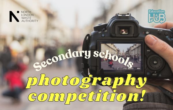 A view through the lens of a camera as someone takes a photo of a busy street. The words secondary school photography competition. 