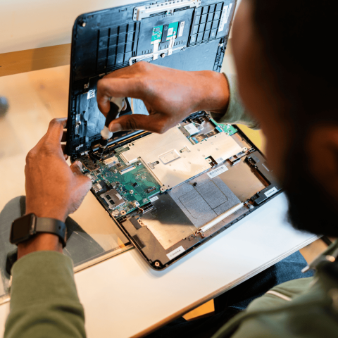 An attendee of the repair workshops repairing a laptop