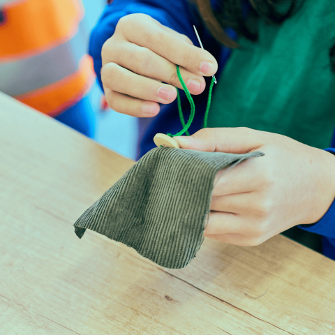 A young person taking part in a sewing workshop