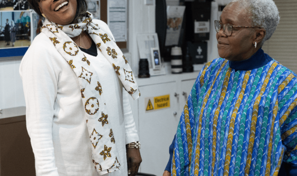 Two ladies laughing over a newly made blouse from a duvet cover